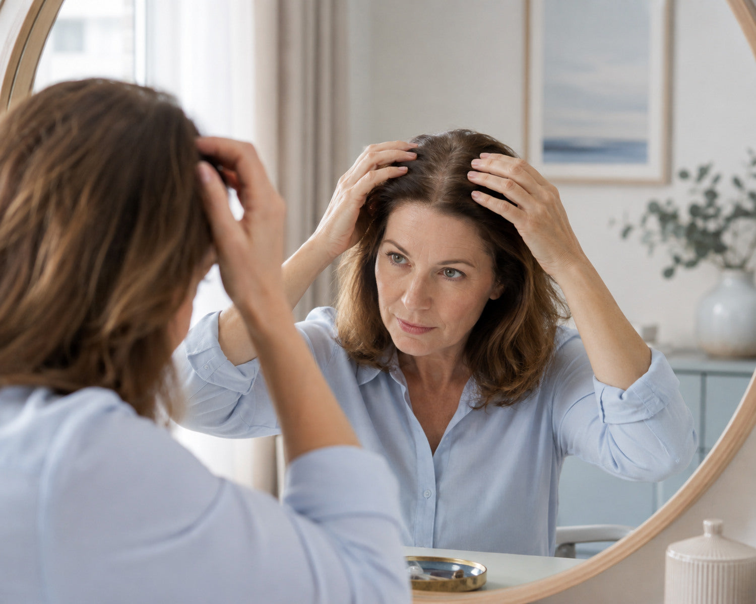 Vrouw bekijkt geleidelijke patroonverdunning rond haar middenscheiding en kruin